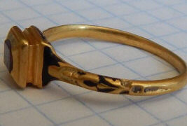 Позднесредневековый золотой перстень с глубокой чеканкой чернением и красным камнем